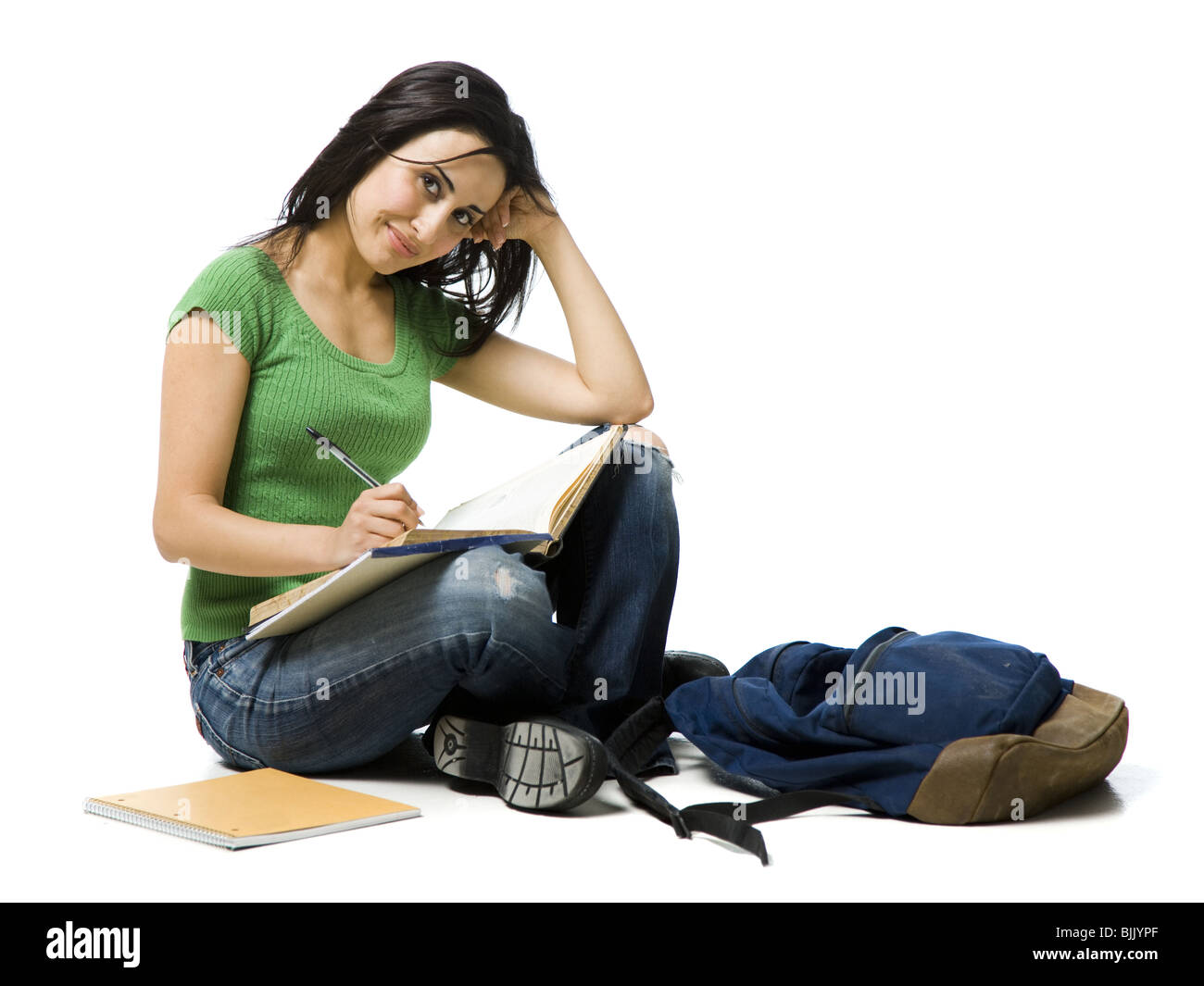 Donna seduta zampe a croce con zaino facendo i compiti di scuola Foto Stock