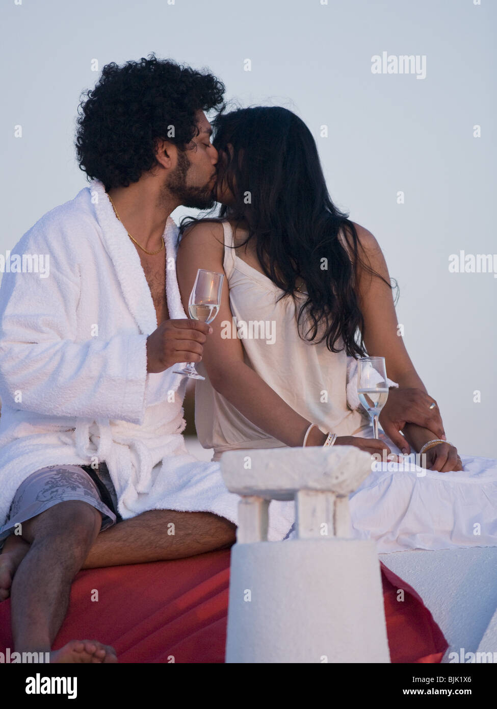Giovane baciare e snuggling all aperto con champagne flauti Foto Stock