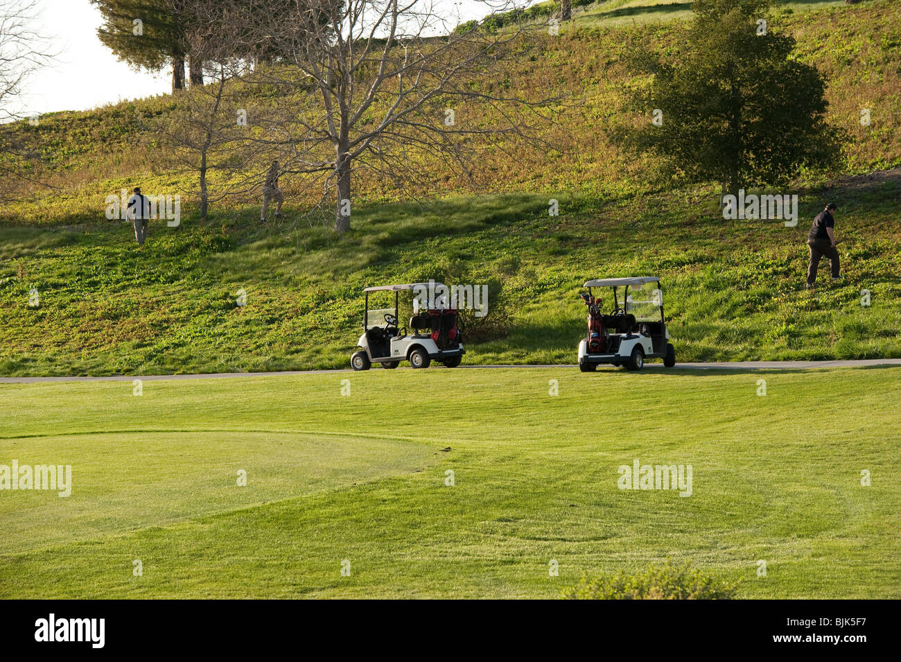 Tre giocatori che cercano per le loro palle perse sul verde Foto Stock