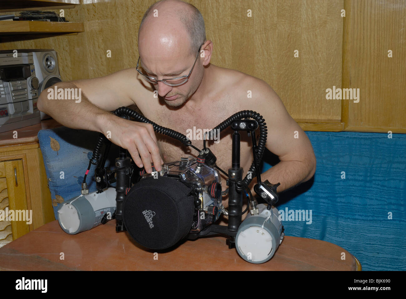 L'uomo nel controllo della sua fotocamera digitale attraverso un alloggiamento Foto Stock