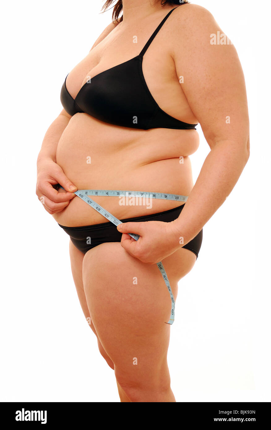 Donna sovrappeso misurando il suo corpo Foto Stock
