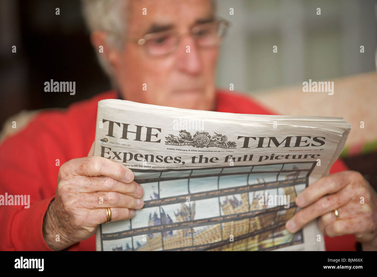 Anziano gentiluomo leggendo il giornale di tempi con la headline, spese, il quadro completo. Foto Stock
