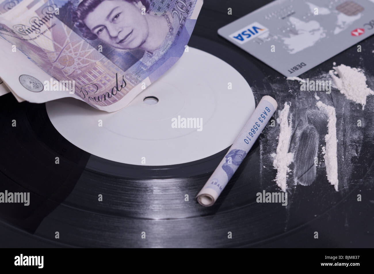 Una foto che mostra il consumo di cocaina nel settore della musica con linee di polvere bianca su una etichetta bianca e record di contanti nel Regno Unito Foto Stock