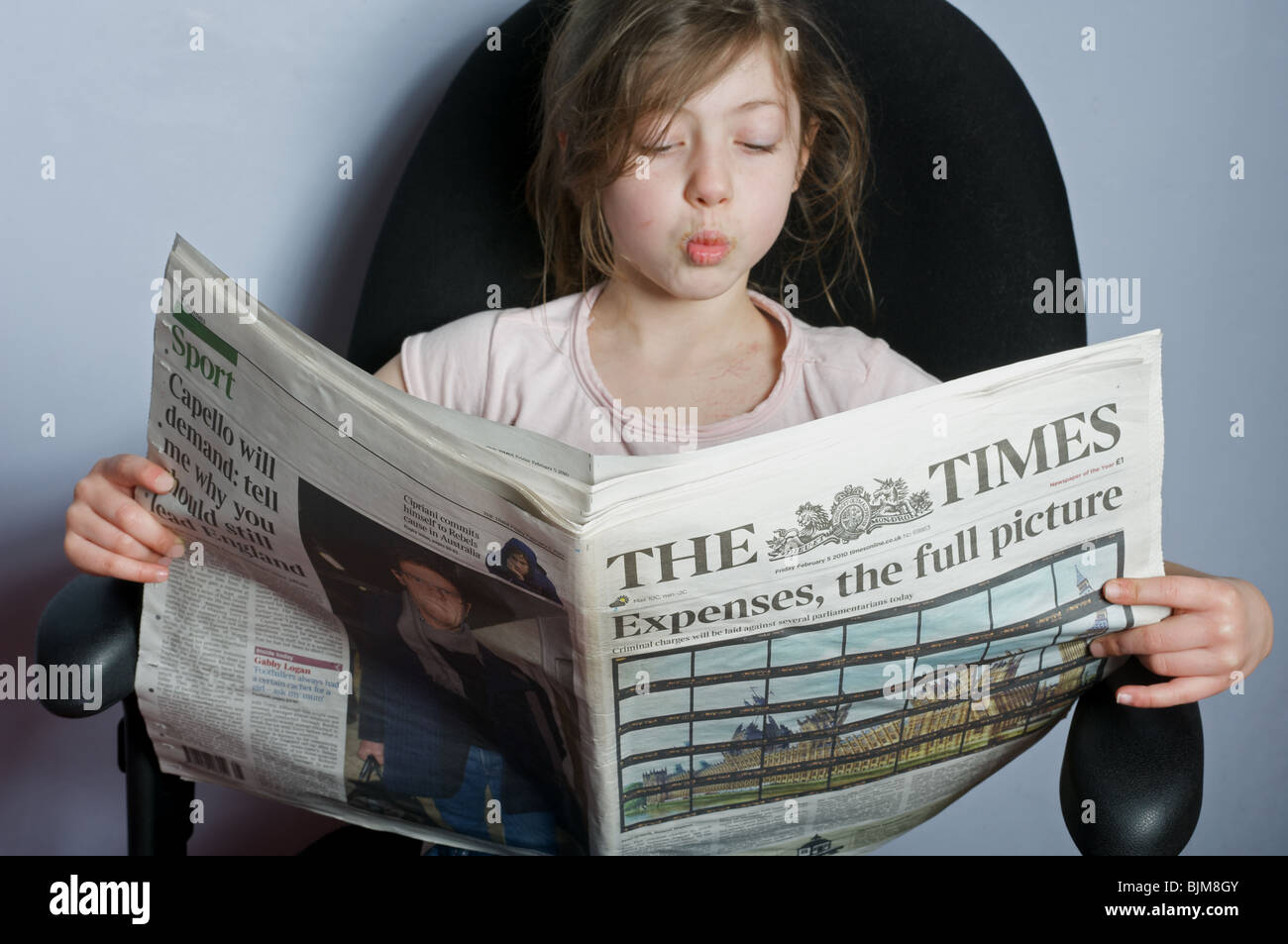 6 anno di lettura della ragazza una copia del giornale di tempi Foto Stock