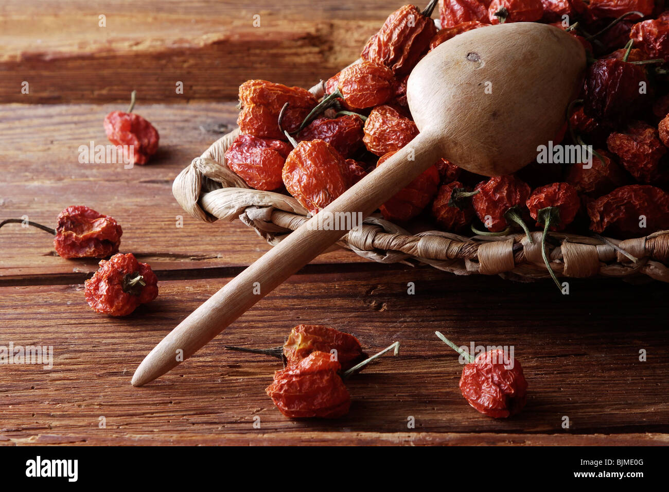 Mini-Peppers (capsicum) in un cesto di vimini su un rustico sfondo di legno Foto Stock