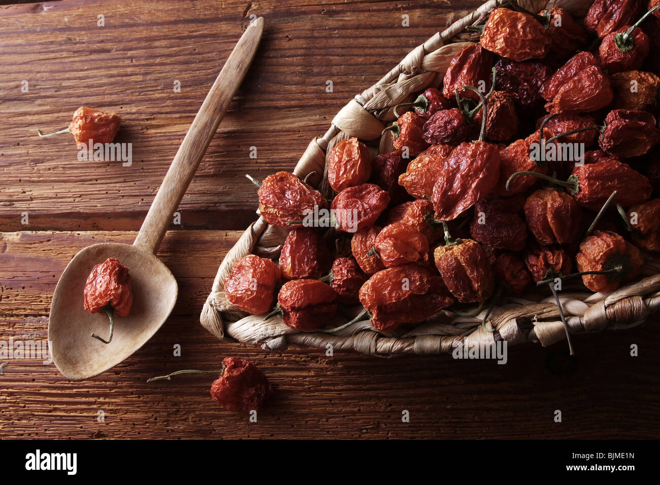 Mini-Peppers (capsicum) in un cesto di vimini su un rustico sfondo di legno Foto Stock