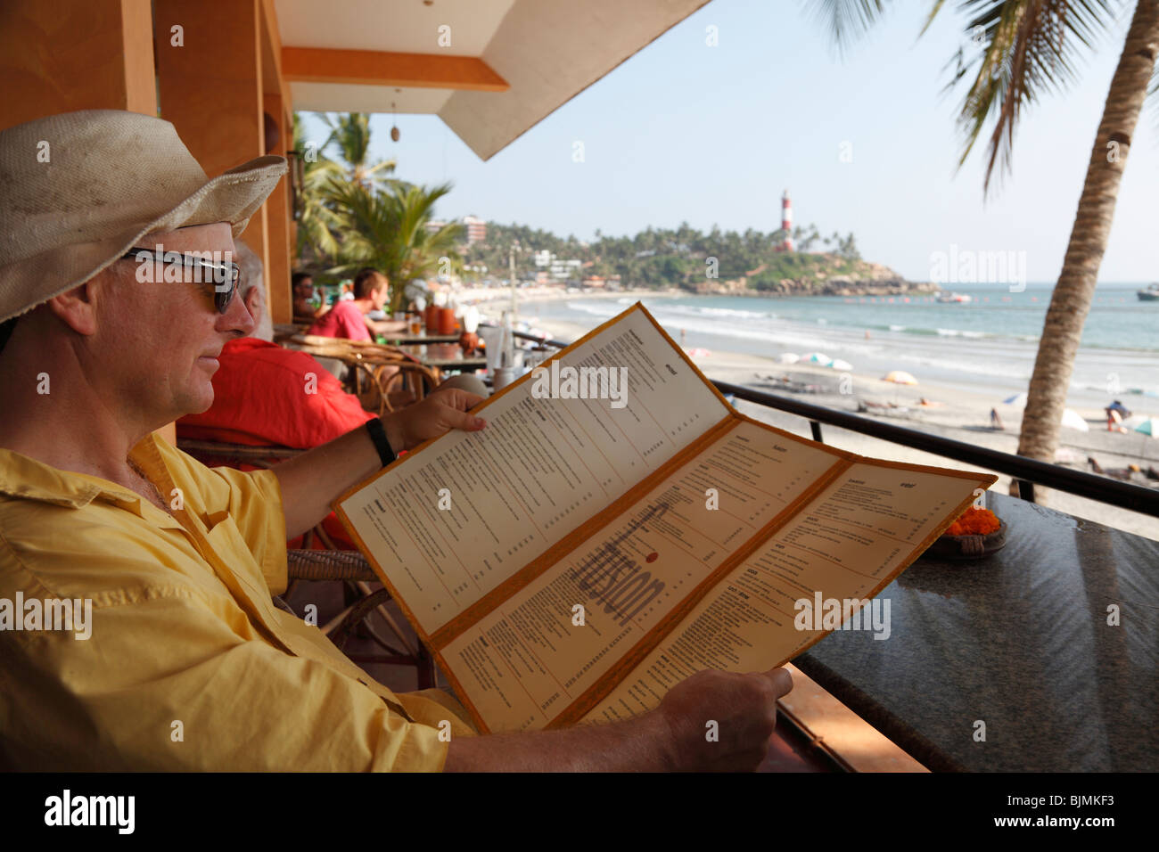 Lettura turistica del menu di un caffè sulla spiaggia del Faro, Kovalam, Malabarian Costa, il Malabar, Kerala, India, Asia Foto Stock
