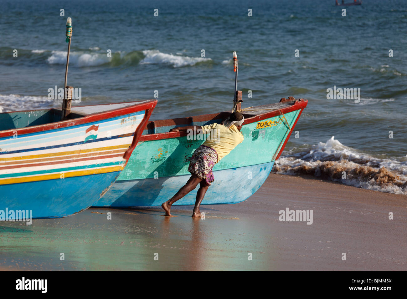 I pescatori spingendo le loro barche da pesca in mare, Somatheram Beach, Malabarian Costa, il Malabar, Kerala, India, Asia Foto Stock
