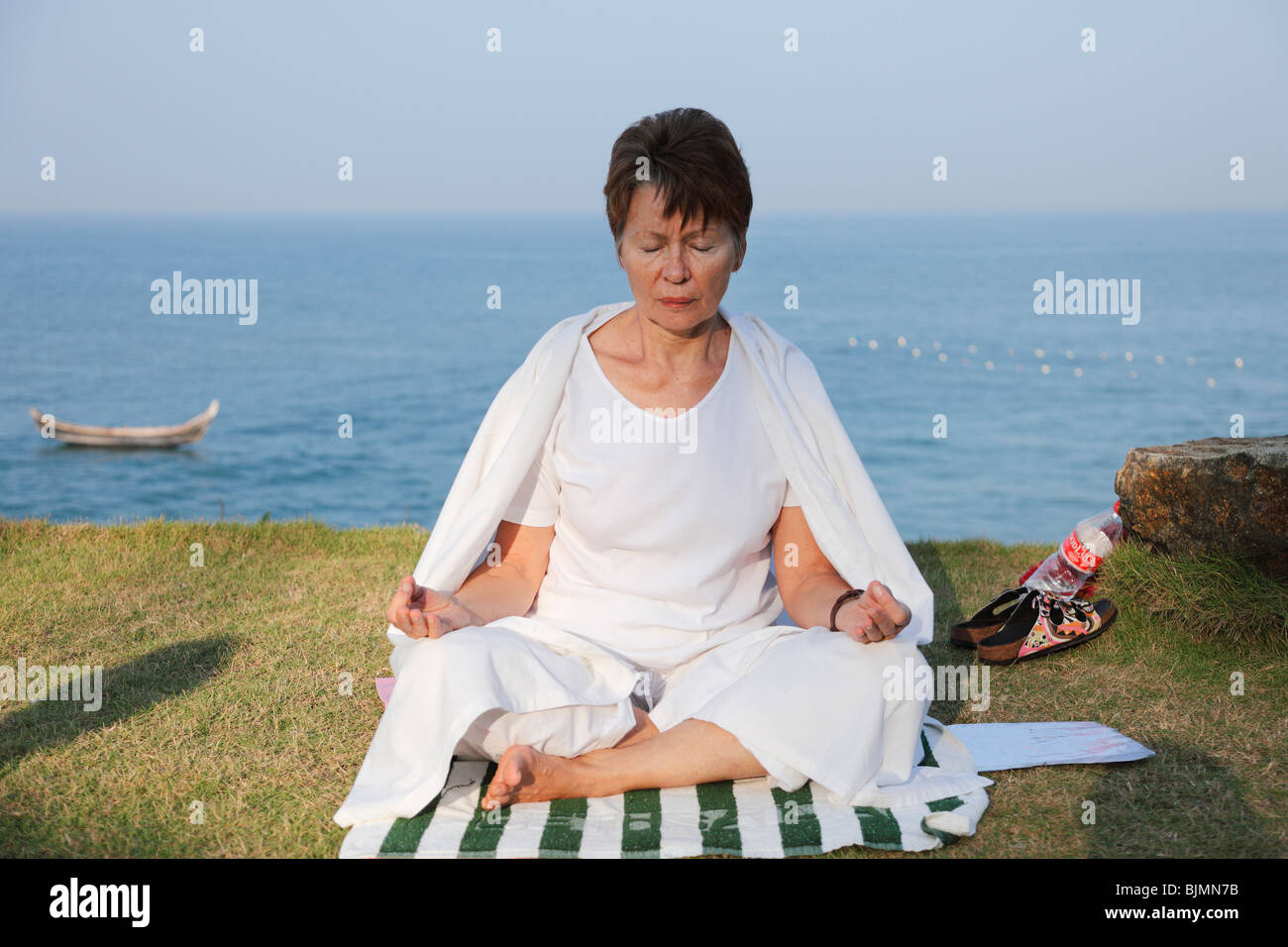 Donna meditando su un prato sopra il mare, Betsaida eremo vicino a Kovalam, Kerala, India meridionale, India, Asia Foto Stock