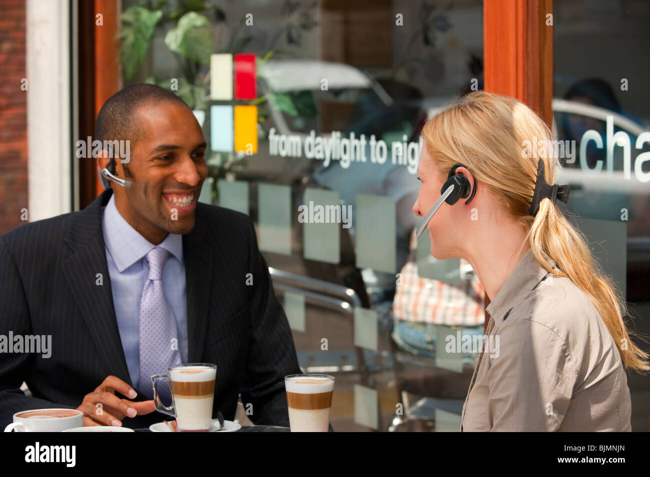 Maschio e femmina di bere il caffè che indossa auricolari - bianco e nero giovane modello completamente rilasciato Foto Stock