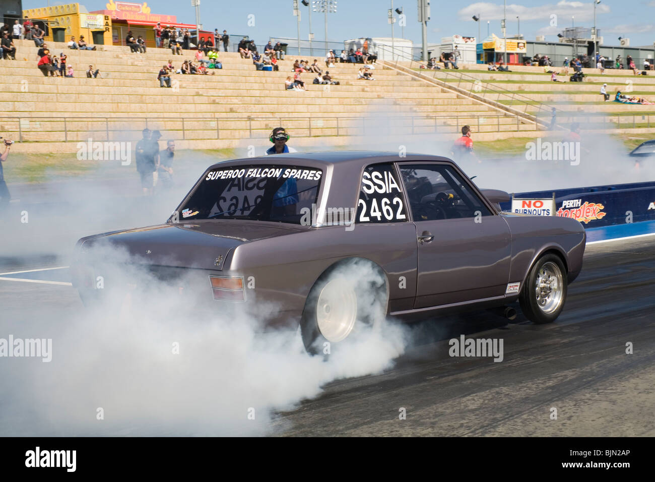 Anni sessanta Ford Cortina drag racing car eseguendo un burnout prima di racing al Motorplex Perth in Australia Occidentale Foto Stock