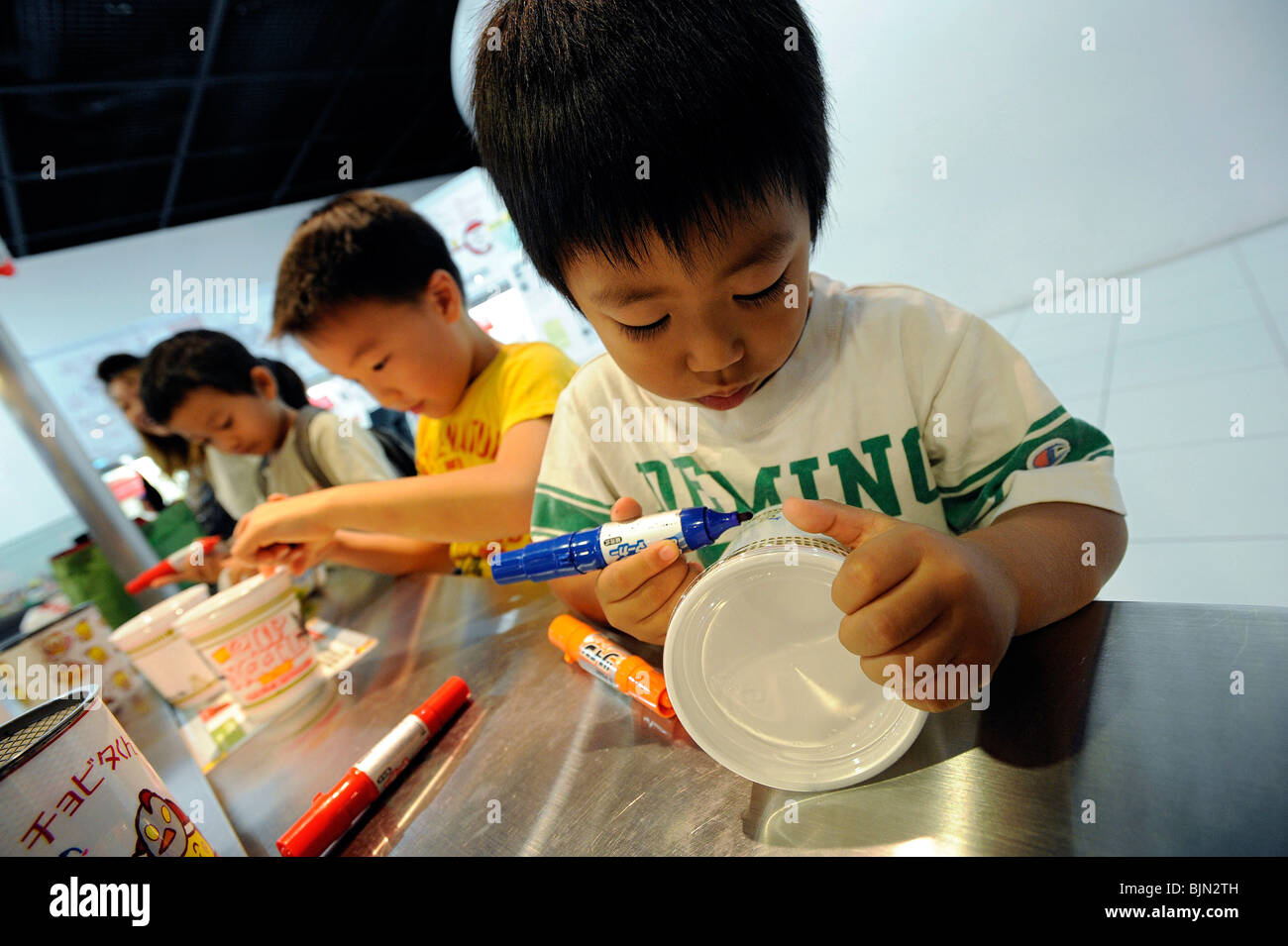 I bambini godono di progettare le loro proprie e originali cup noodle tazze all'interno del Momofuku Ando Instant Ramen Museum Foto Stock