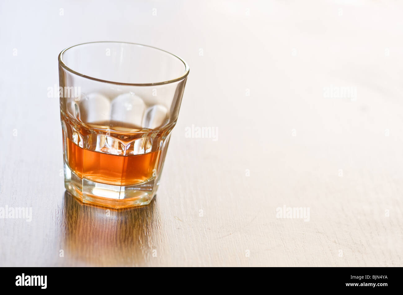 Bicchiere di whiskey sul contatore di legno Foto Stock