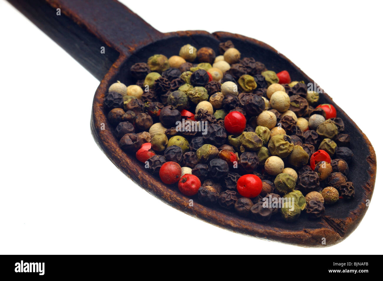 Grani di pepe di colore sul cucchiaio di legno Foto Stock