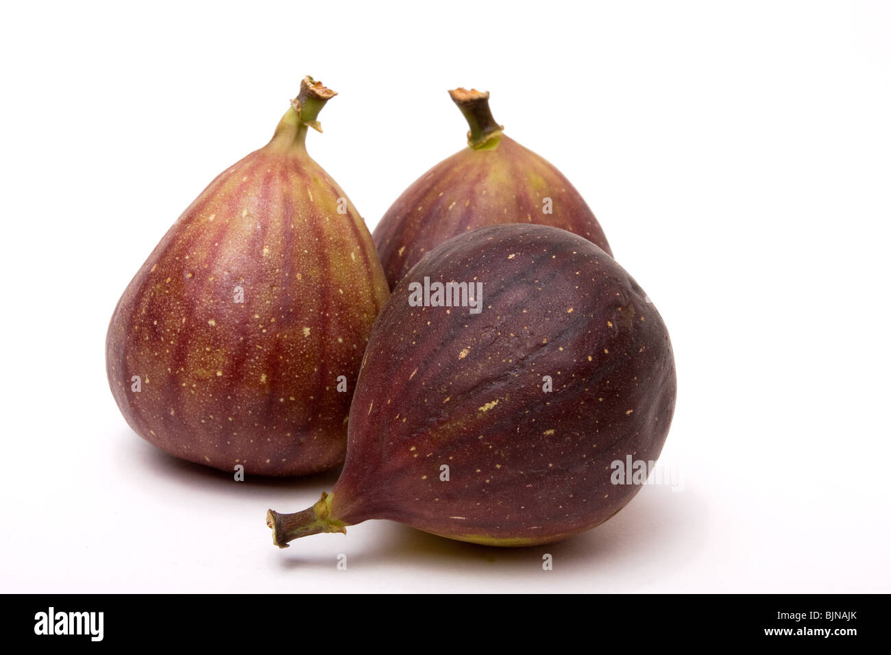 Tre fichi maturi isolati contro uno sfondo bianco. Foto Stock