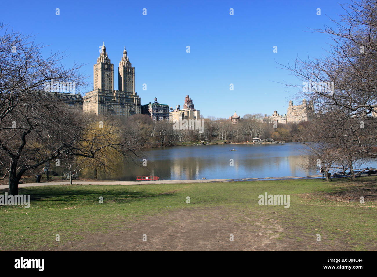 Il lago a Central Park con il Central Park West e la San Remo appartamenti in background. Foto Stock