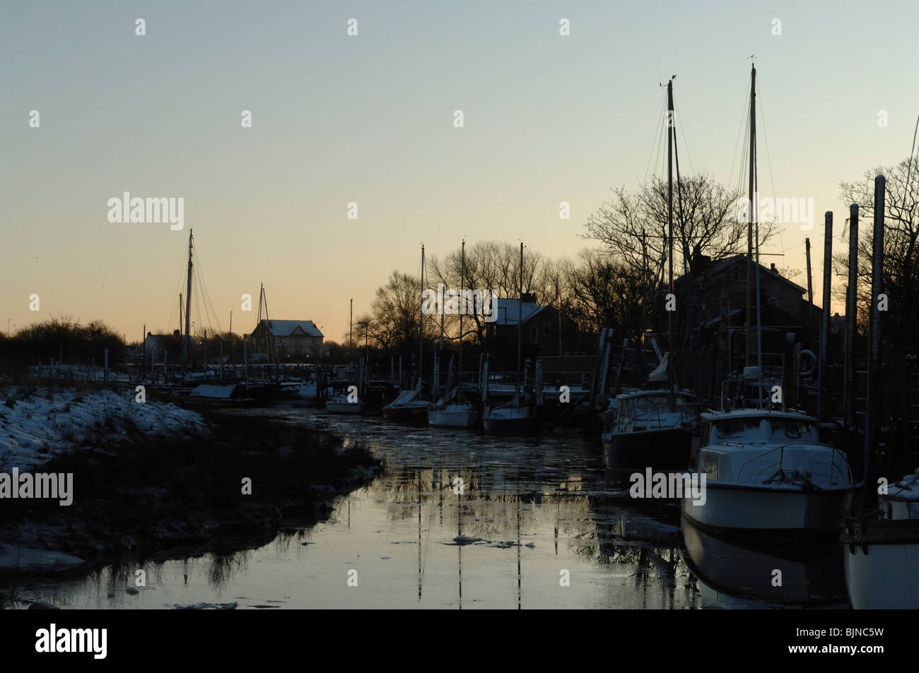 Yacht ormeggiati a banchine su skippool creek finalmente la luce in inverno. Foto Stock