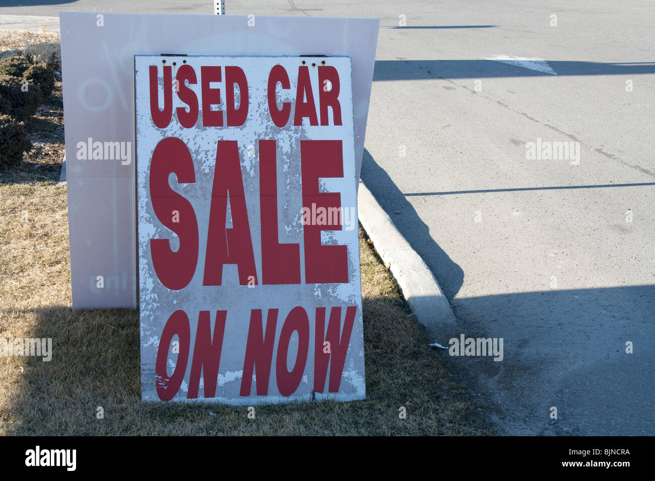 Auto usate in vendita ora segno concessionario concessionaria imboccare la strada del mercato di strada sul marciapiede Foto Stock