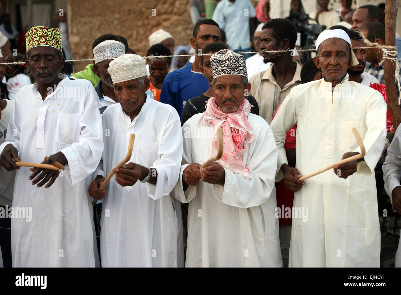 Uomini compiono gli Stick dance Kirumbizi durante maulidi fuori moschea Riyadha Lamu Kenya Foto Stock