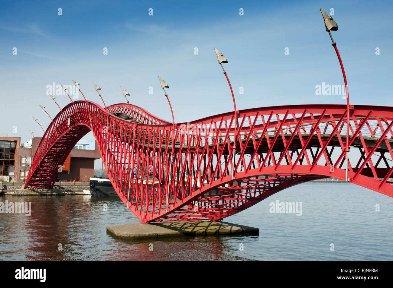 Rosso moderno ponte pedonale in acciaio chiamato Pythonbrug nuovo collegamento Borneo e Sporenburg isola quartiere di Amsterdam Paesi Bassi Foto Stock