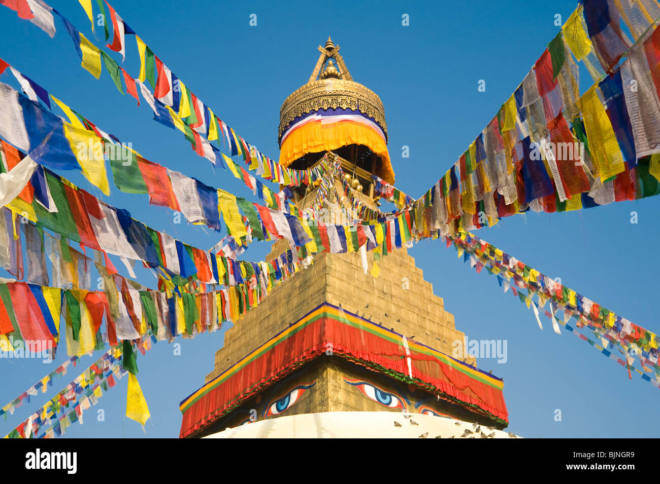 La parte superiore della Stupa Boudhanath con molti tibetani bandiere di preghiera a Kathmandu in Nepal Foto Stock