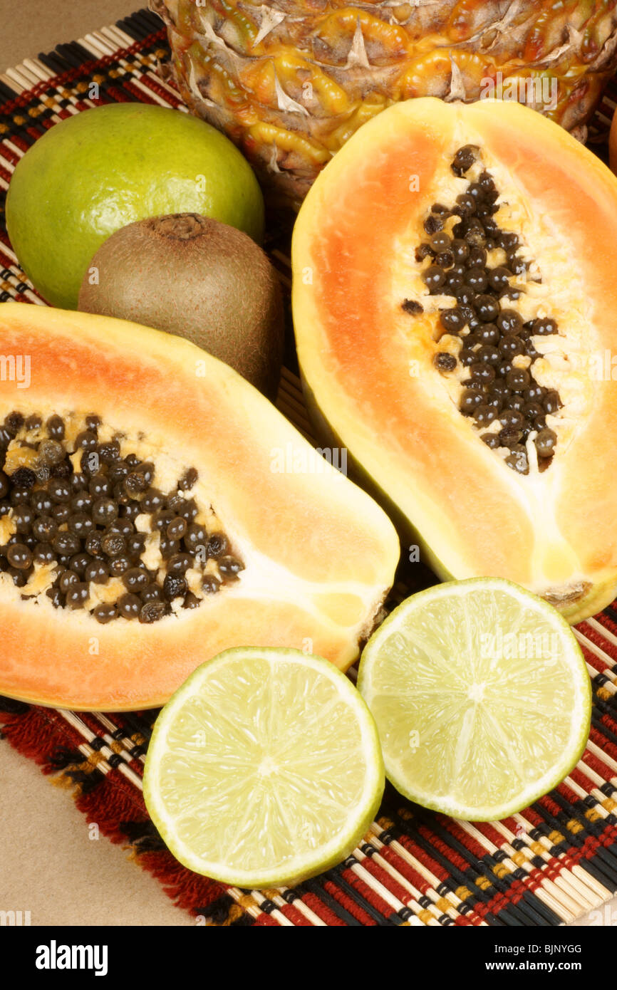 La frutta tropicale composizione con un mezzo taglio papaia, calce, ananas e kiwi Foto Stock