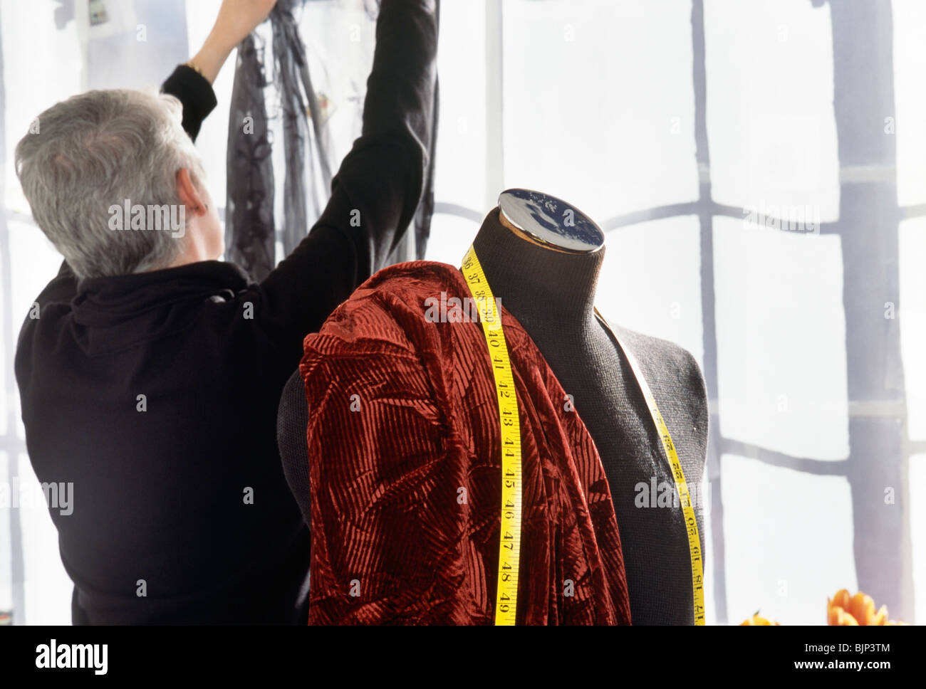Fashion Designer che lavora in studio con tessuto, NYC Foto Stock
