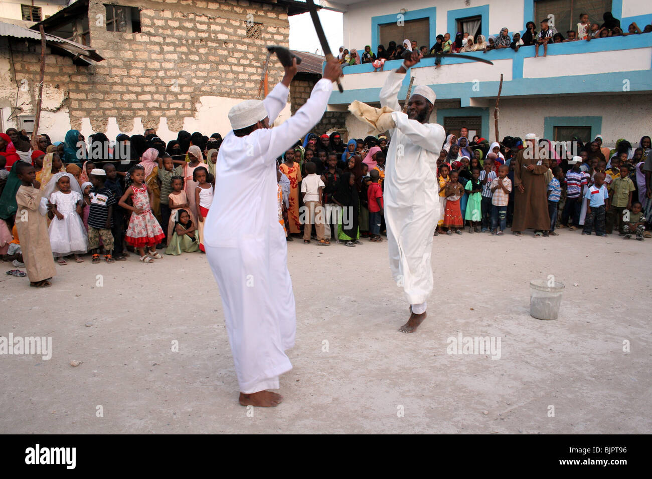 Il swahili uomini prendono parte ad un ballo di spada, Chama durante Maulidi Lamu Foto Stock