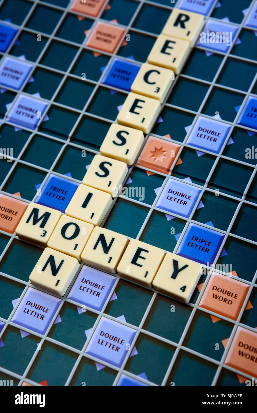 Il denaro e la recessione sillabato su una scheda di Scrabble Foto Stock