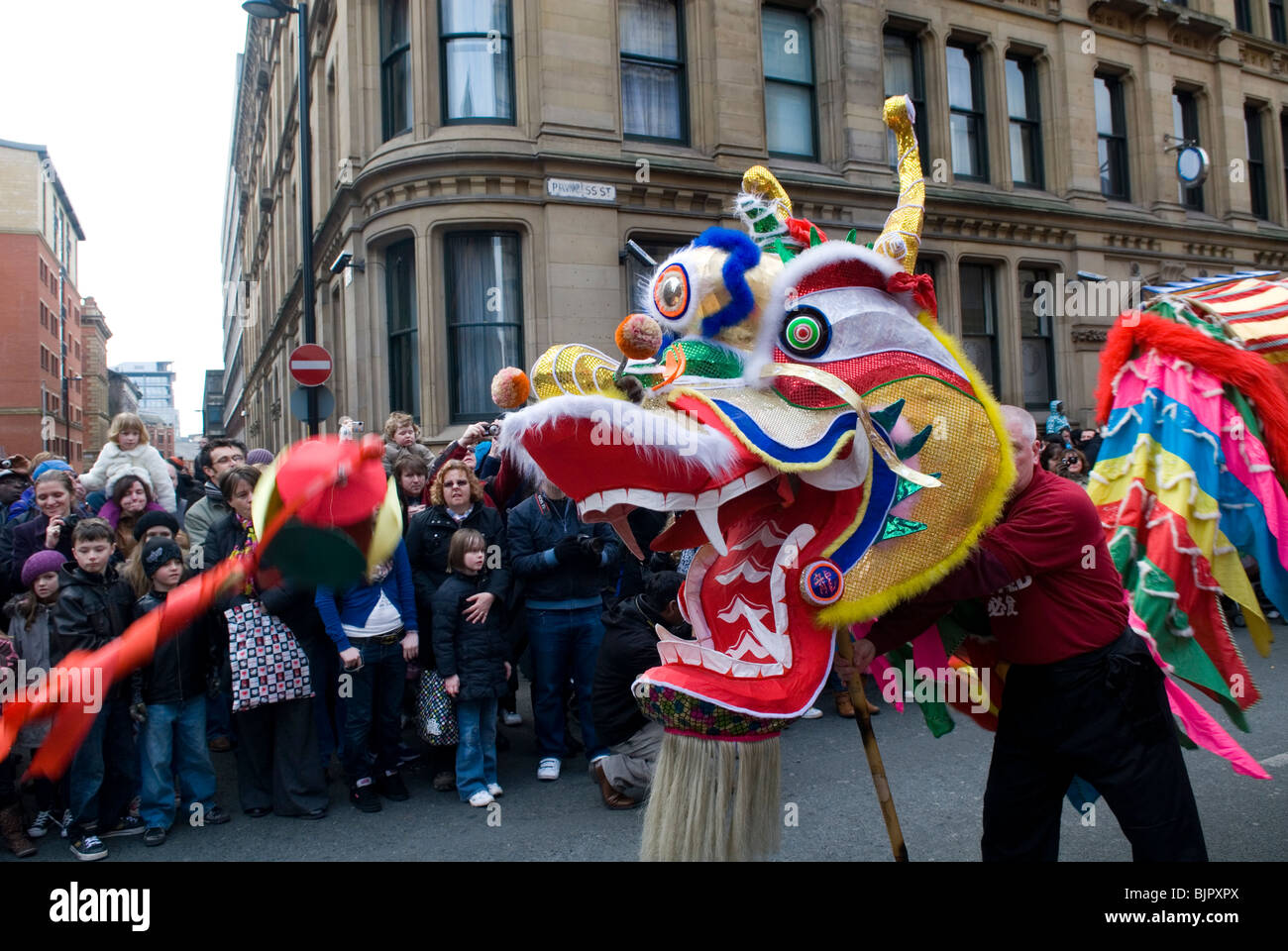 Persone che guardano il Dragon Dance nella celebrazione del Capodanno cinese sfilata in Manchester REGNO UNITO Foto Stock