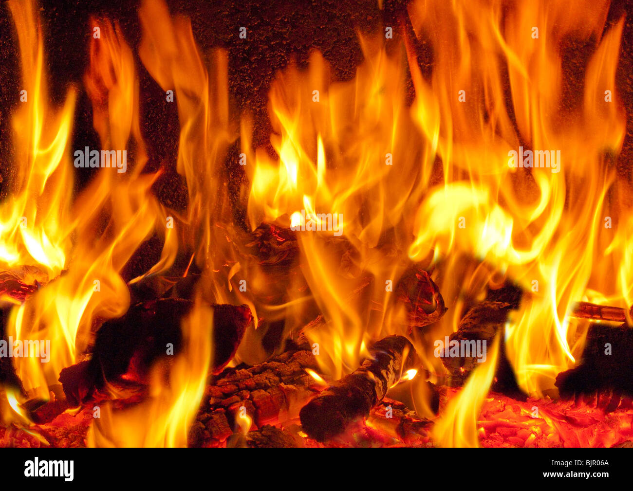 Un fiammeggiante fuoco log in una stufa a legna Foto Stock
