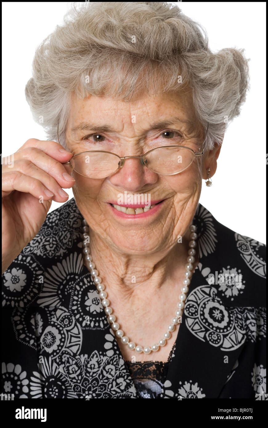 Senior donna con gli occhiali guardando severamente alla fotocamera. Foto Stock