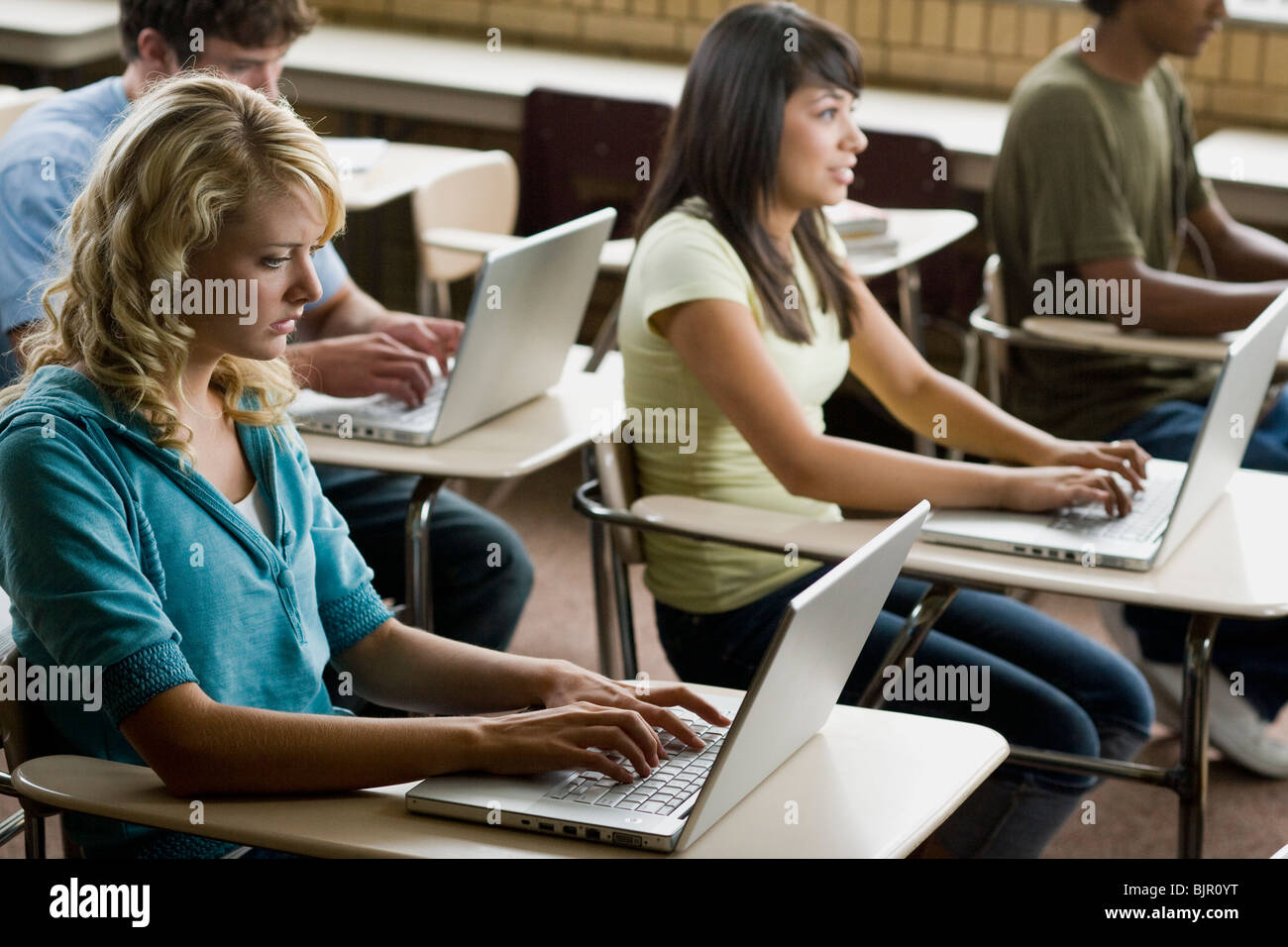 Quattro studenti di lavorare su computer portatili. Foto Stock