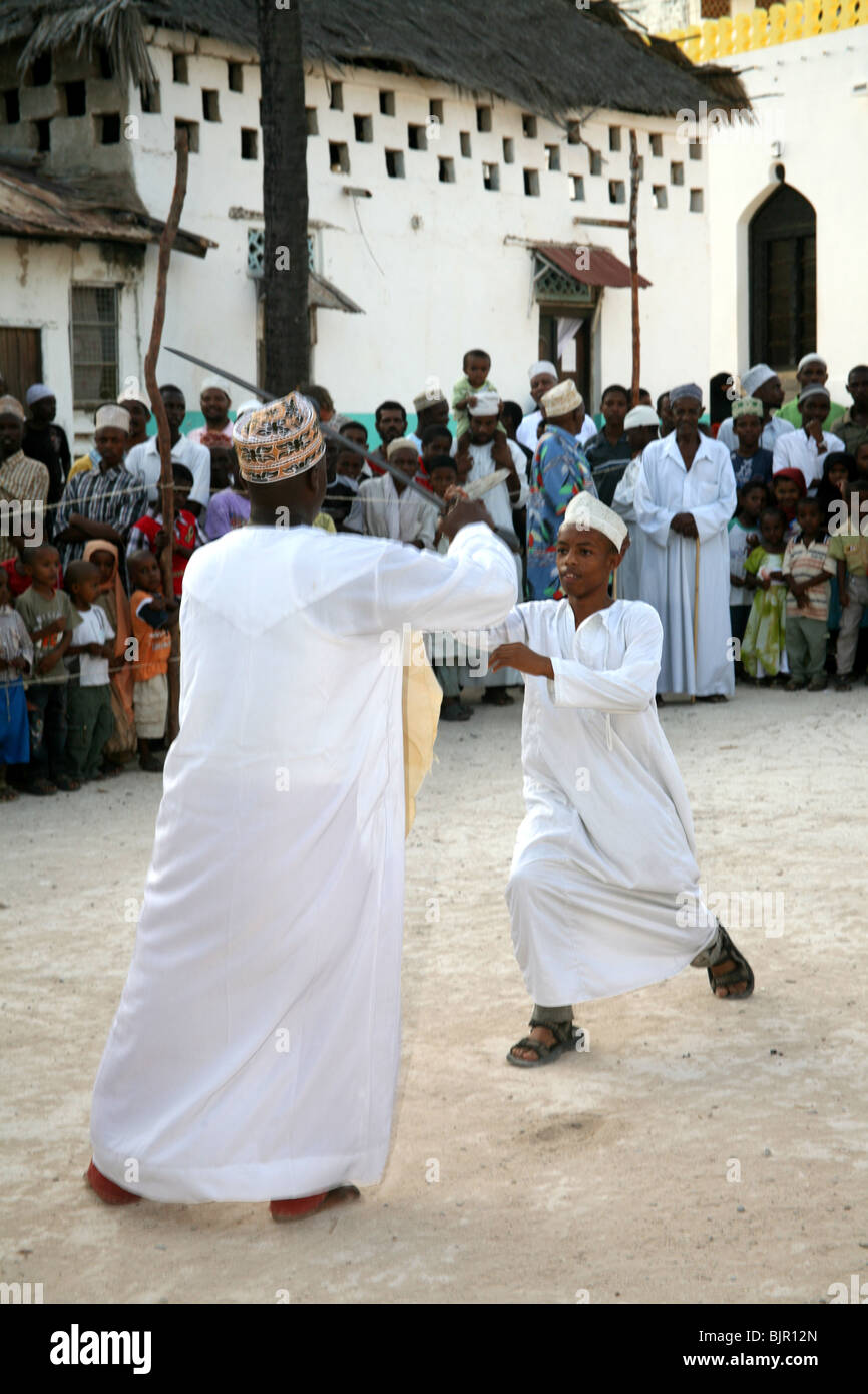 Il swahili uomini prendono parte ad un ballo di spada, Chama durante Maulidi Lamu Foto Stock