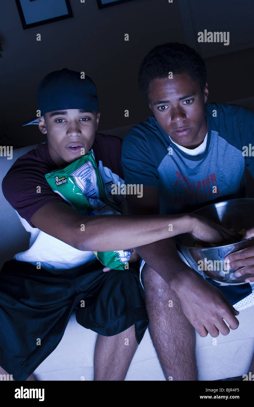 Due ragazzi adolescenti mangiando snack Foto Stock