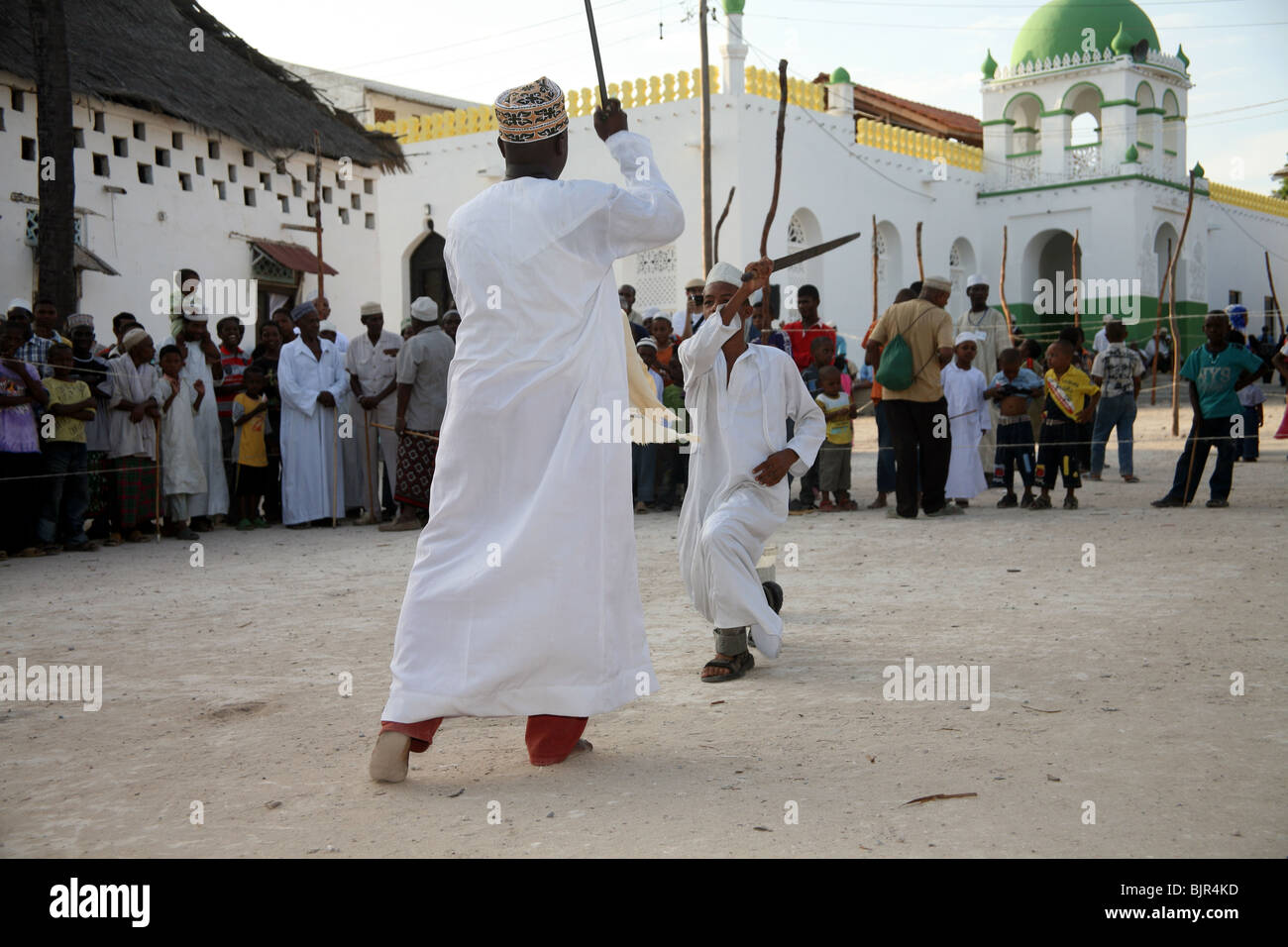Il swahili uomini prendono parte ad un ballo di spada, Chama durante Maulidi Lamu Foto Stock