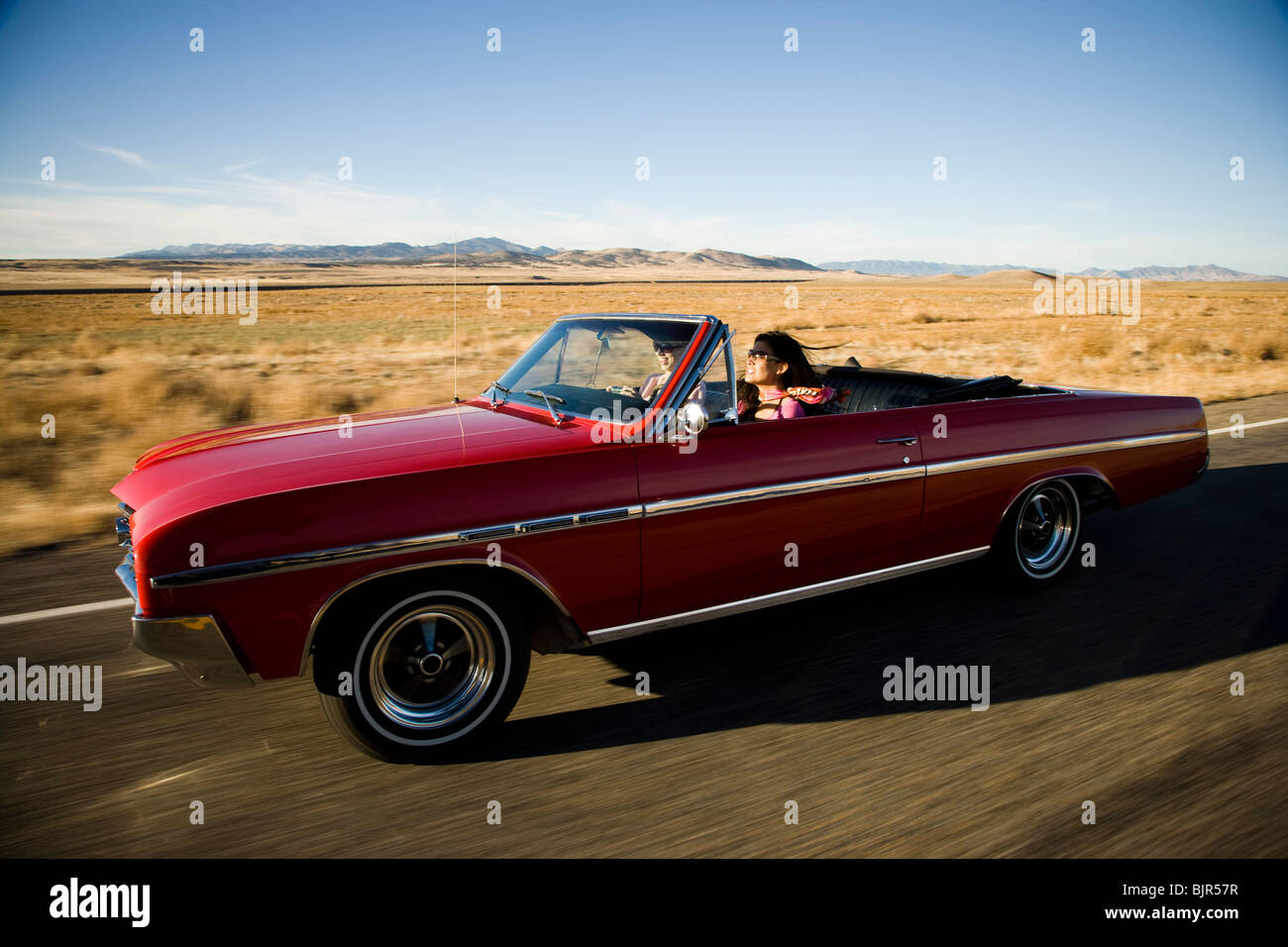 Rosso auto guidando lungo la strada Foto Stock