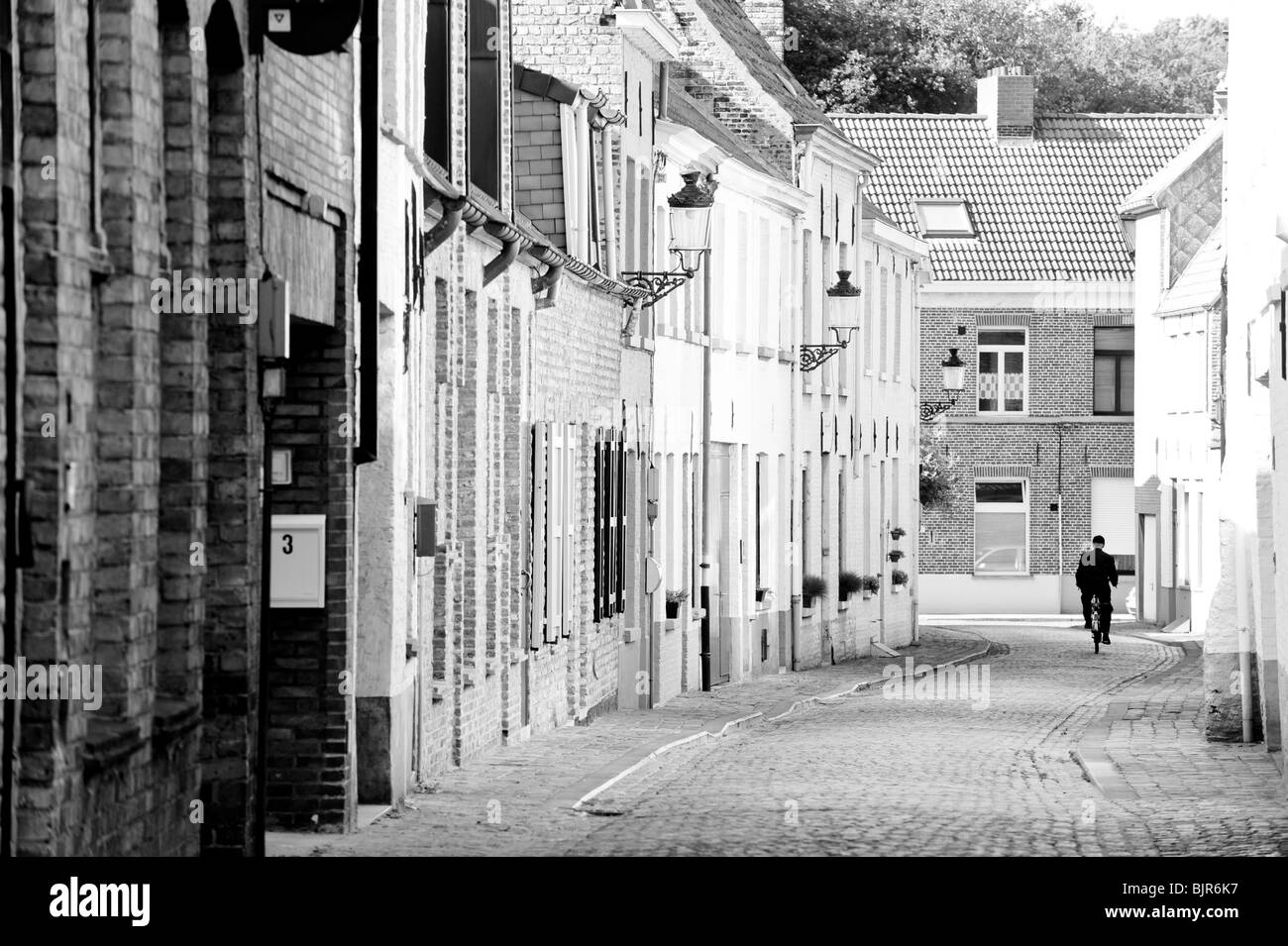 Si tratta di una immagine di una strada a Bruxelles in Belgio con un uomo in bicicletta di distanza. Foto Stock