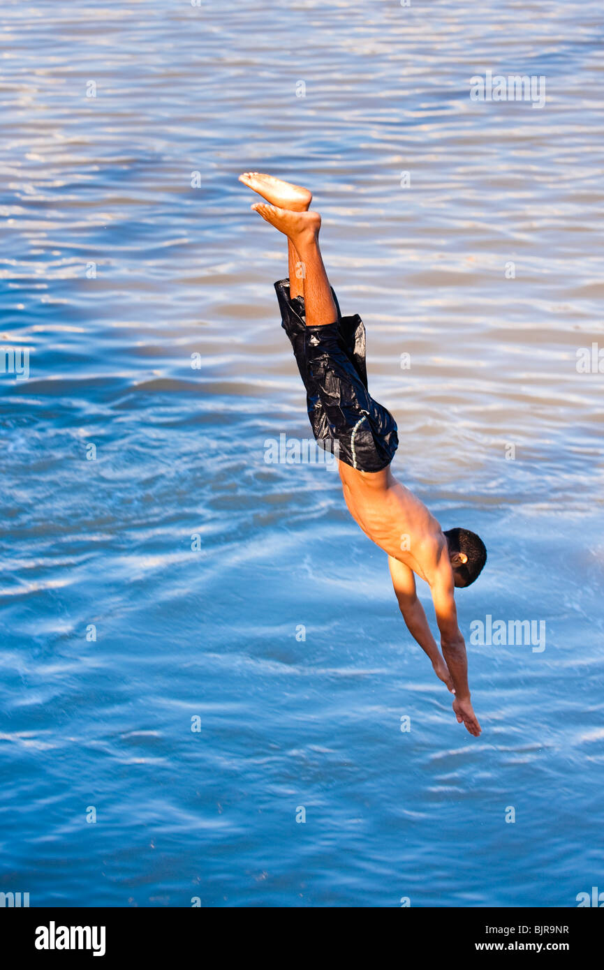 Si tratta di un immagine di un giovane uomo di tuffi in acqua. Foto Stock