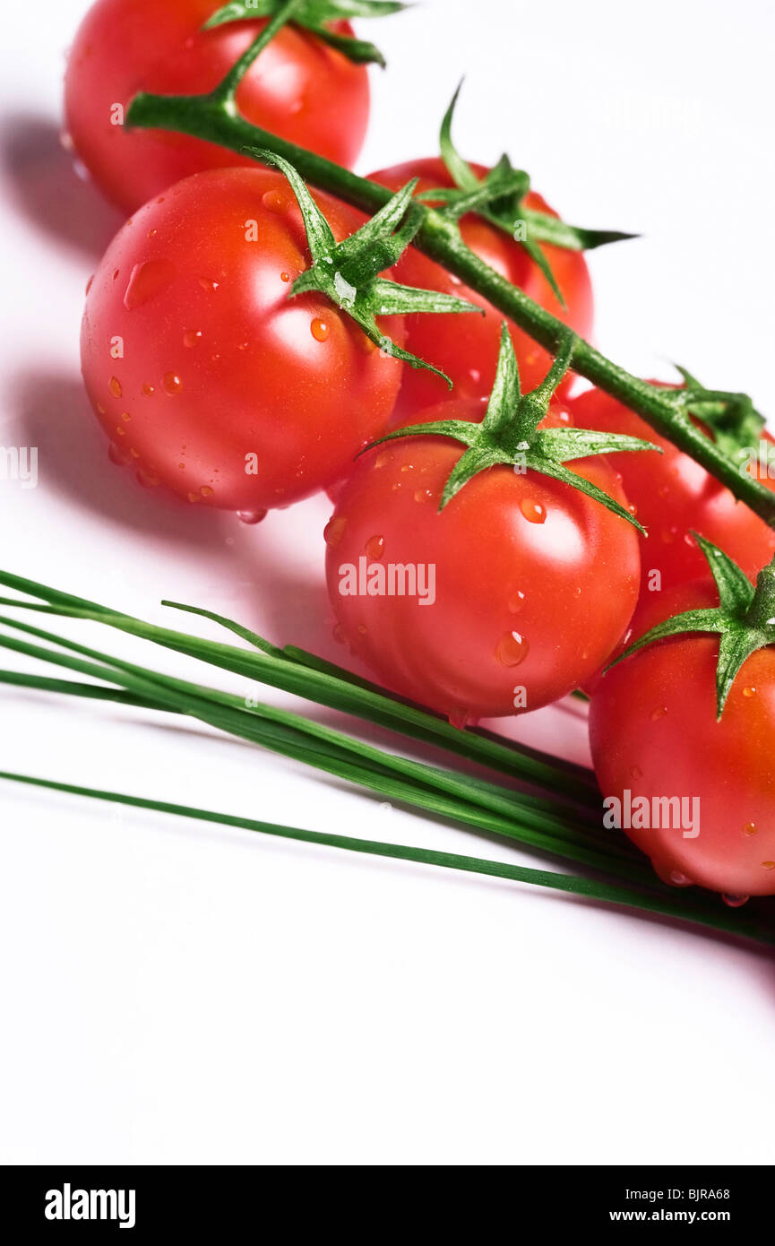 Fresco e umido e tomatoe erba cipollina sul tavolo Foto Stock