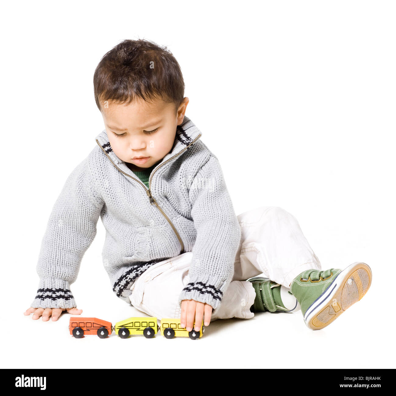 Baby boy (18-23 mesi) giocando con Toy Cars, contro uno sfondo bianco Foto Stock