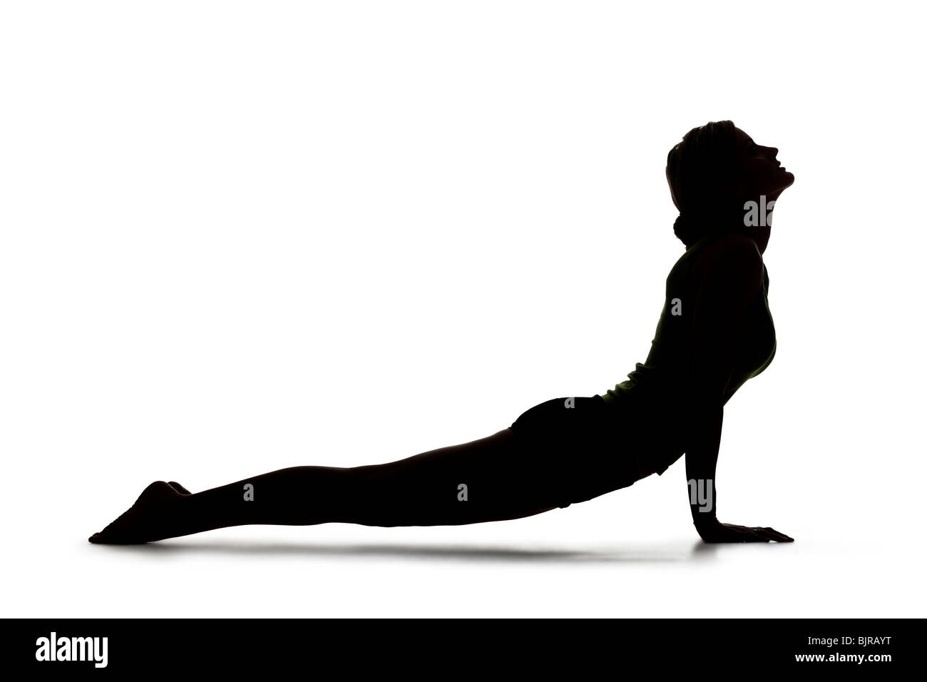 Stati Uniti d'America, Utah, Orem, Silhouette di donna in posa cobra contro uno sfondo bianco Foto Stock Stati Uniti d'America, Utah, Orem, Silhouette di donna in posa cobra contro uno sfondo bianco Foto Stock