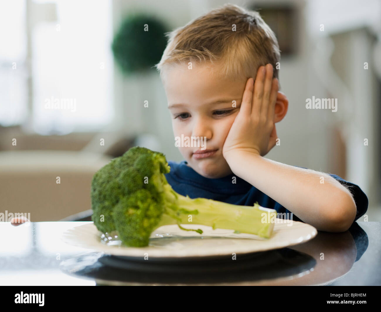 Stati Uniti d'America, Utah, Alpine, ragazzo (6-7) in appoggio la guancia sulla mano dalla piastra di broccoli Foto Stock