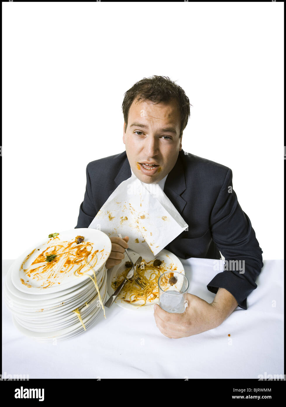 Il sovrappeso imprenditore gorging stesso su spaghetti Foto Stock