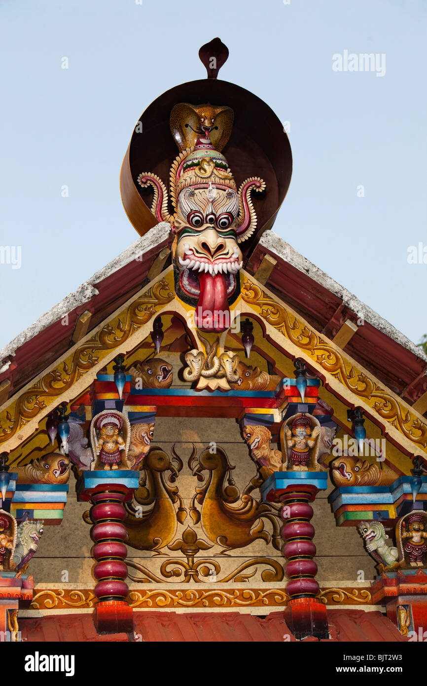India Kerala, Cannanore (Kannur), serpent motif, intagliato e dipinto figure in legno sopra la porta del tempio Foto Stock