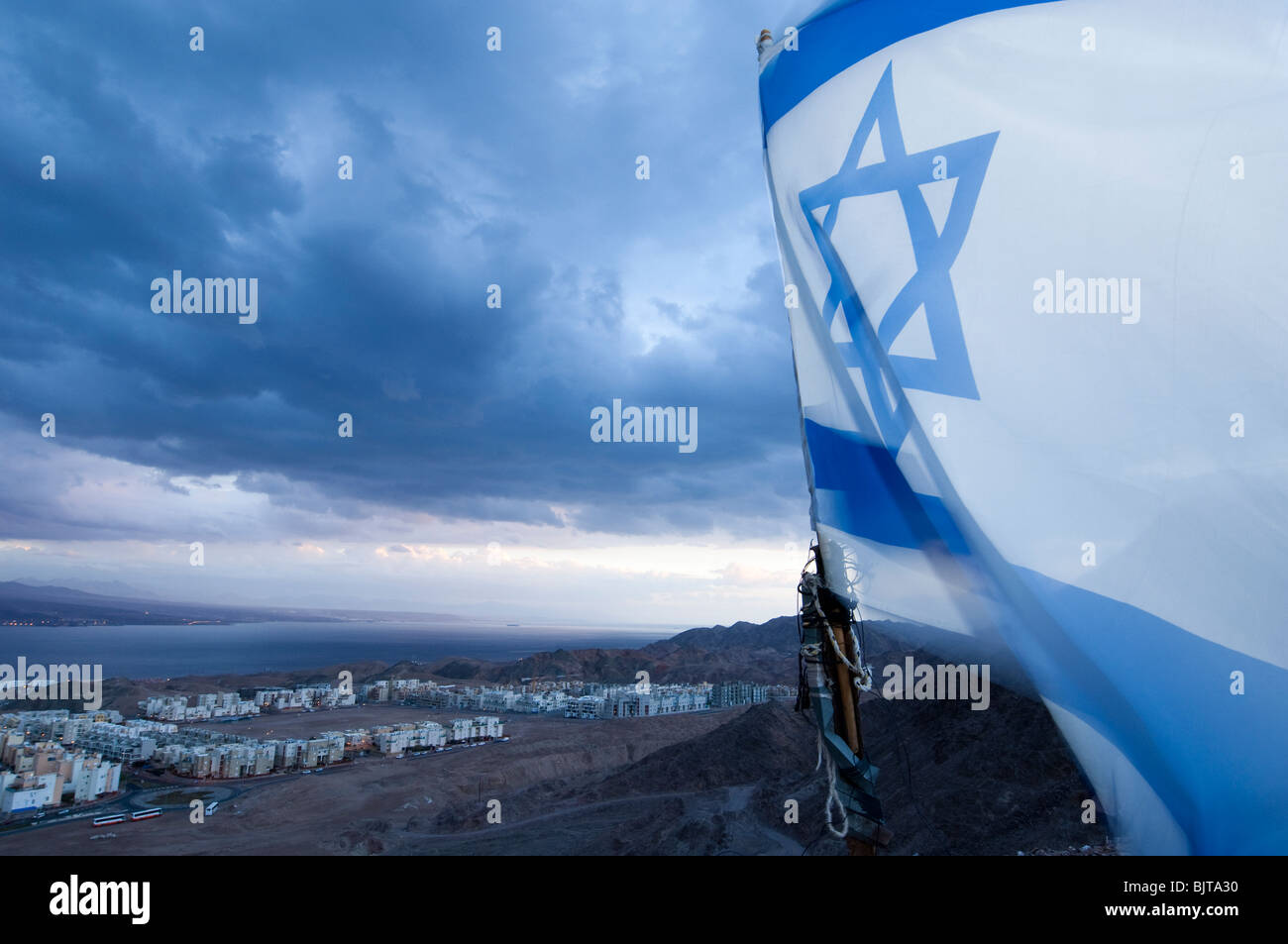 La bandiera di Israele al vento con la città meridionale di Eilat in background Foto Stock