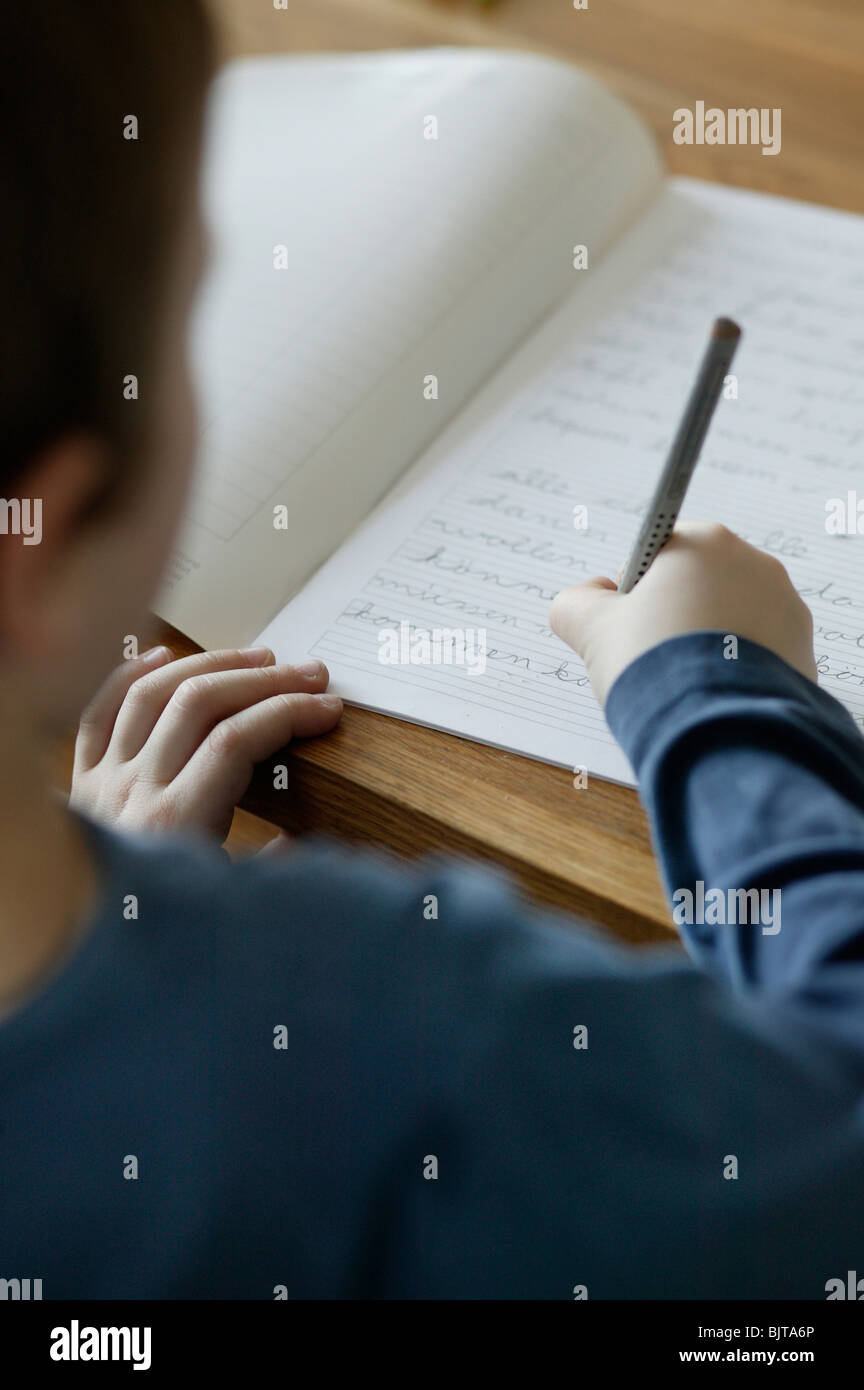 Giovane ragazzo è di mettere in pratica la sua abilità di scrittura, Berlino, Germania Foto Stock