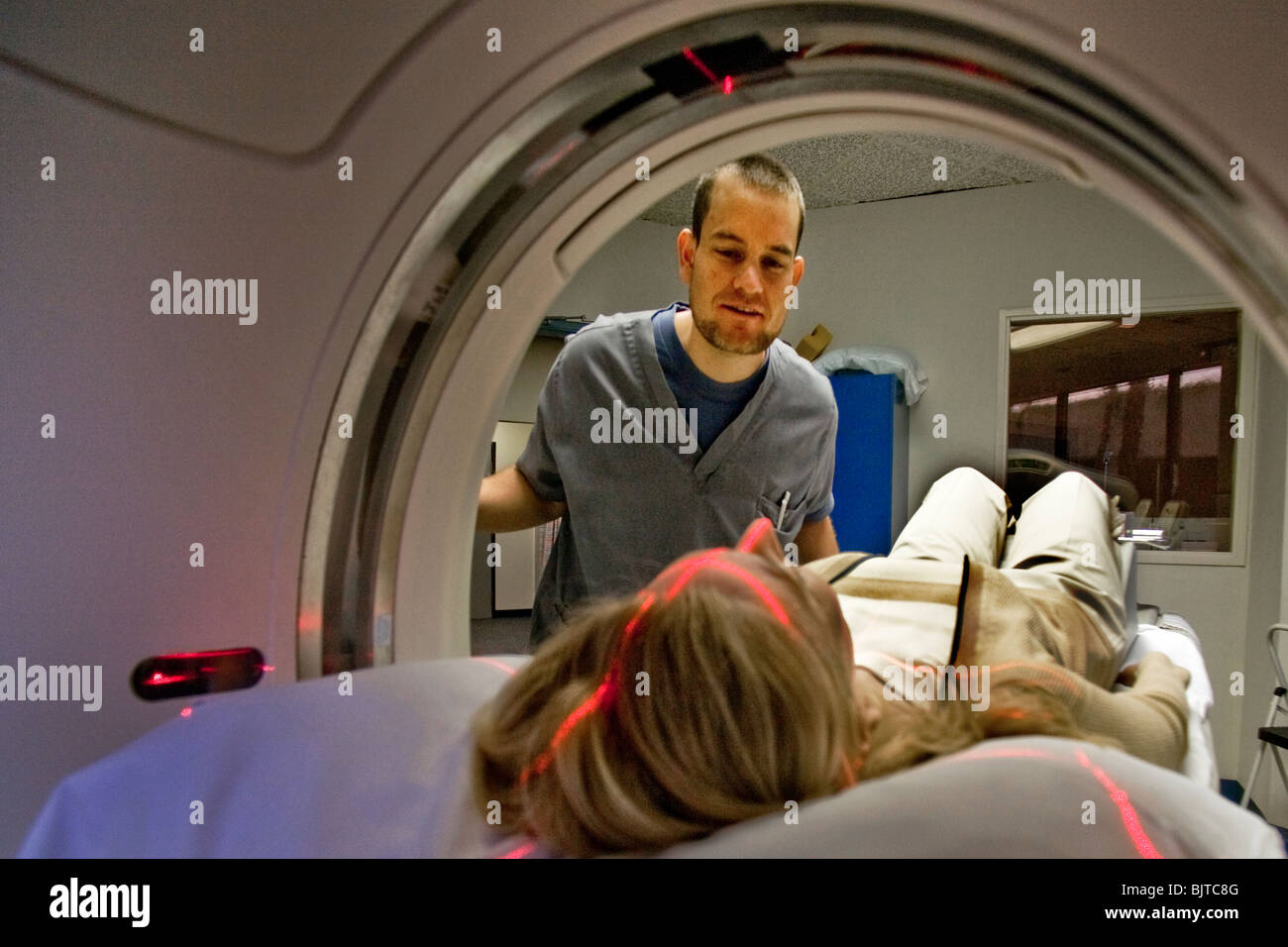 Un operatore medico prepara un paziente per un esame TAC a California studio radiologico usando un multi-slice scanner TC. Foto Stock