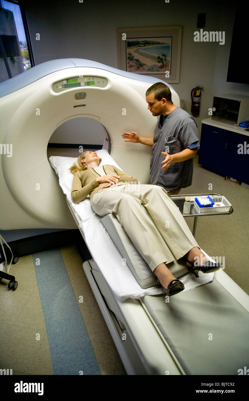 Un operatore medico prepara un paziente per un esame TAC a California studio radiologico usando un multi-slice scanner TC. Foto Stock