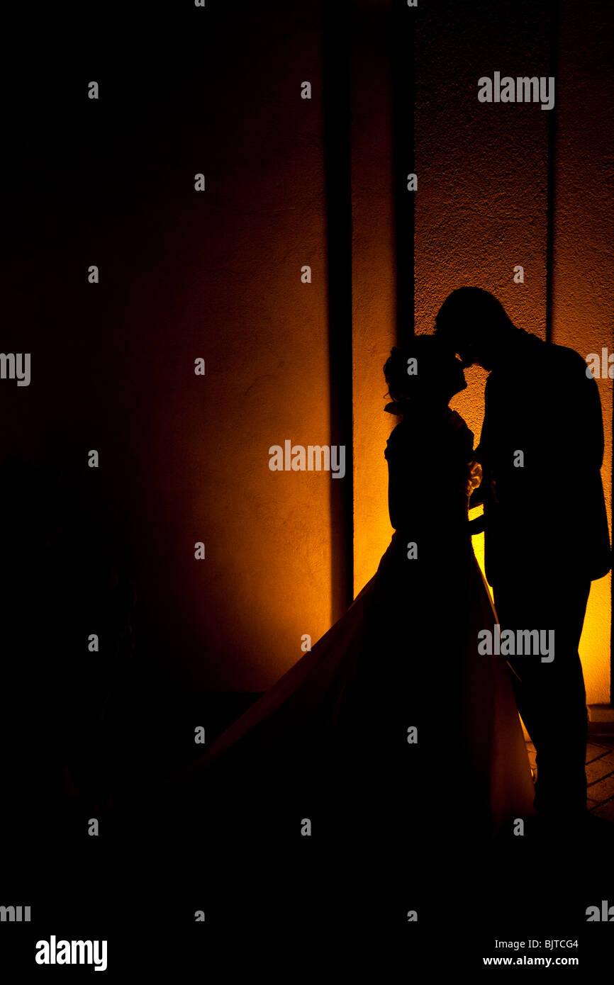 Silhouette di sposa giovane in piedi di fronte gli uni e gli altri e baciare e azienda. Foto Stock